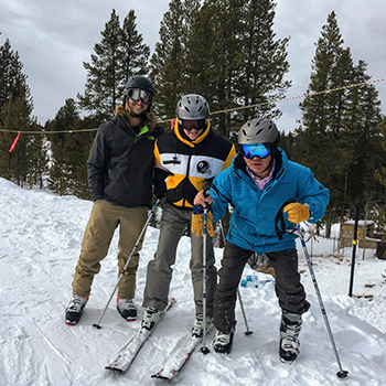 Three skiers pose for photo on slope