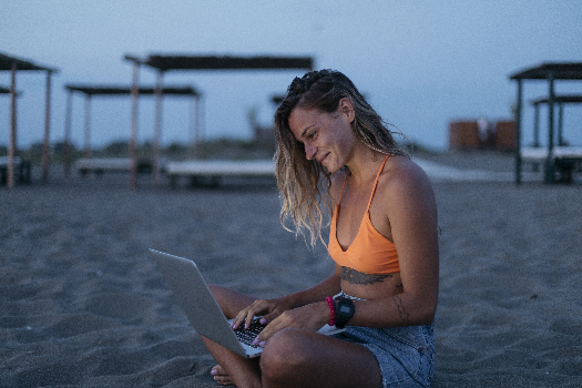Woman on beach using laptop