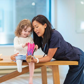 travel nurse helping a child patient with a prosthetic